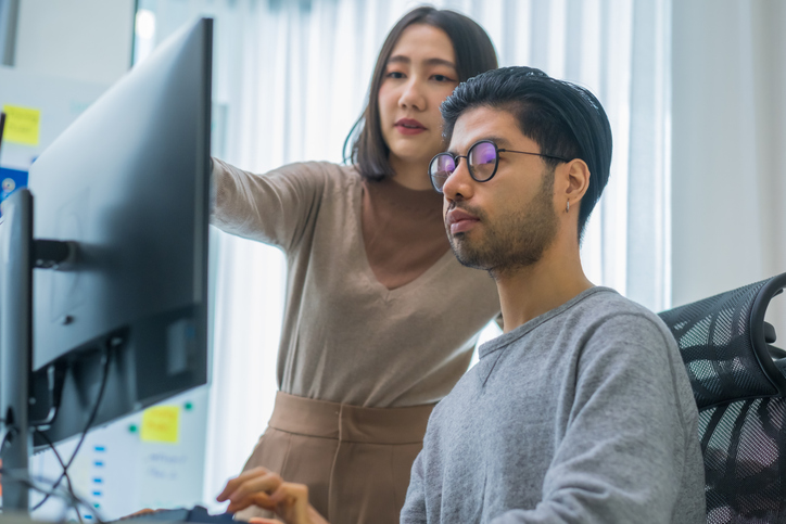 two workers in office learning how to become software engineers