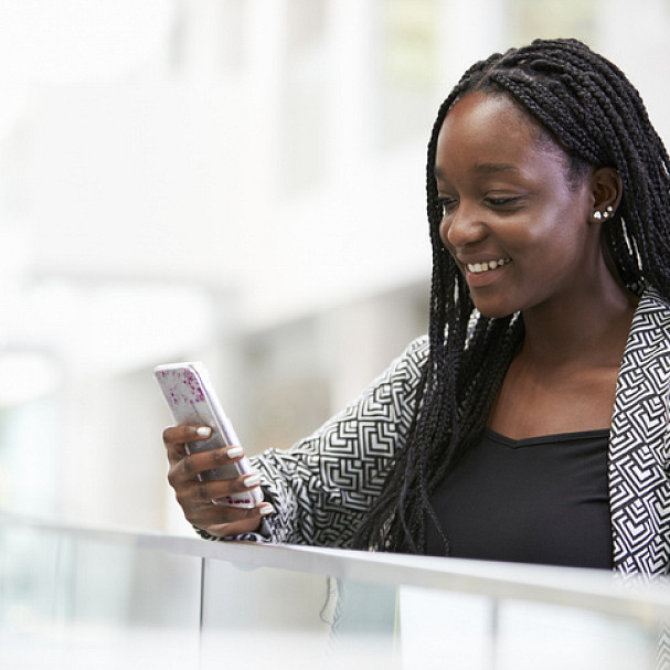 woman looking at her phone and seeing her career goals