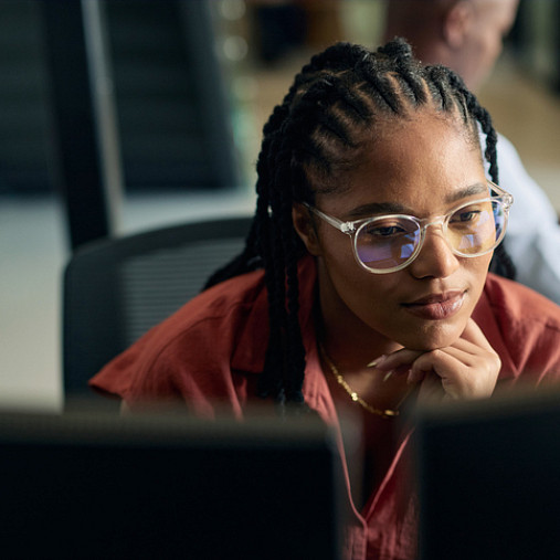 young woman looking at computer screen searching for ai jobs